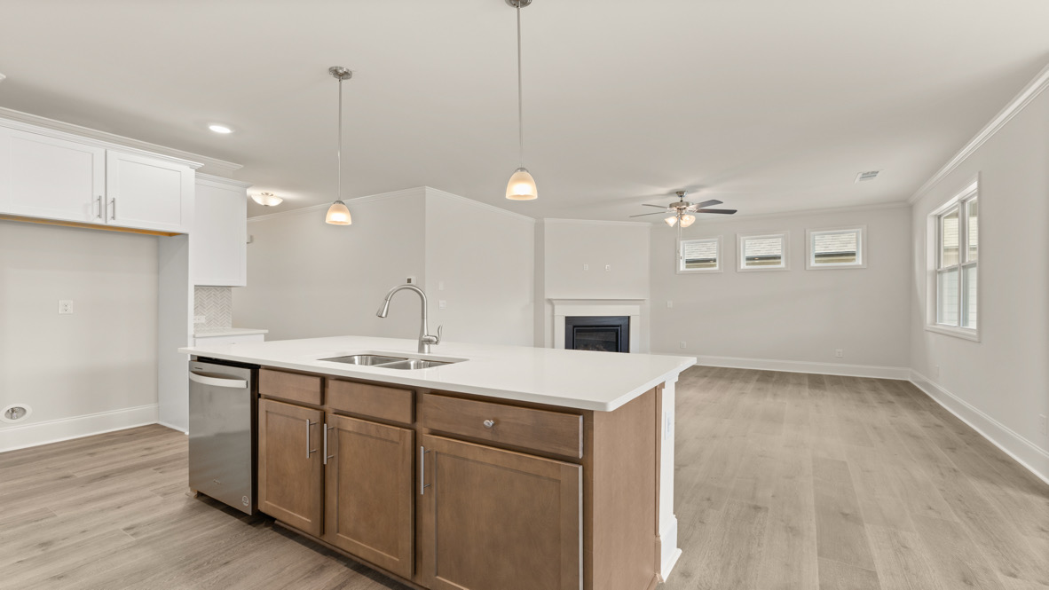 Interior kitchen with center island and white cabinets open to living area
