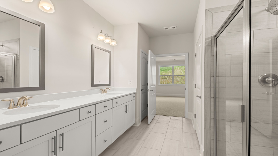 Interior primary bathroom with double sink and shower