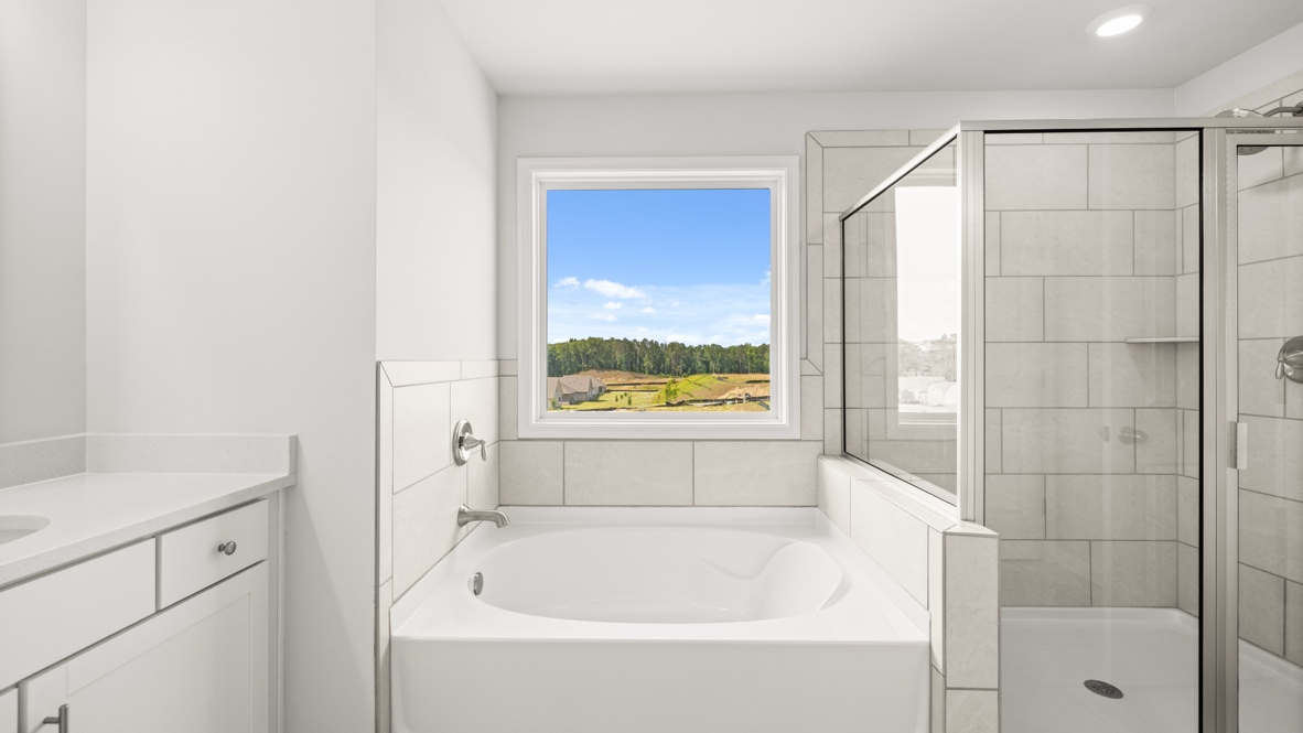 Interior primary bathroom with sinks, bath tub and shower