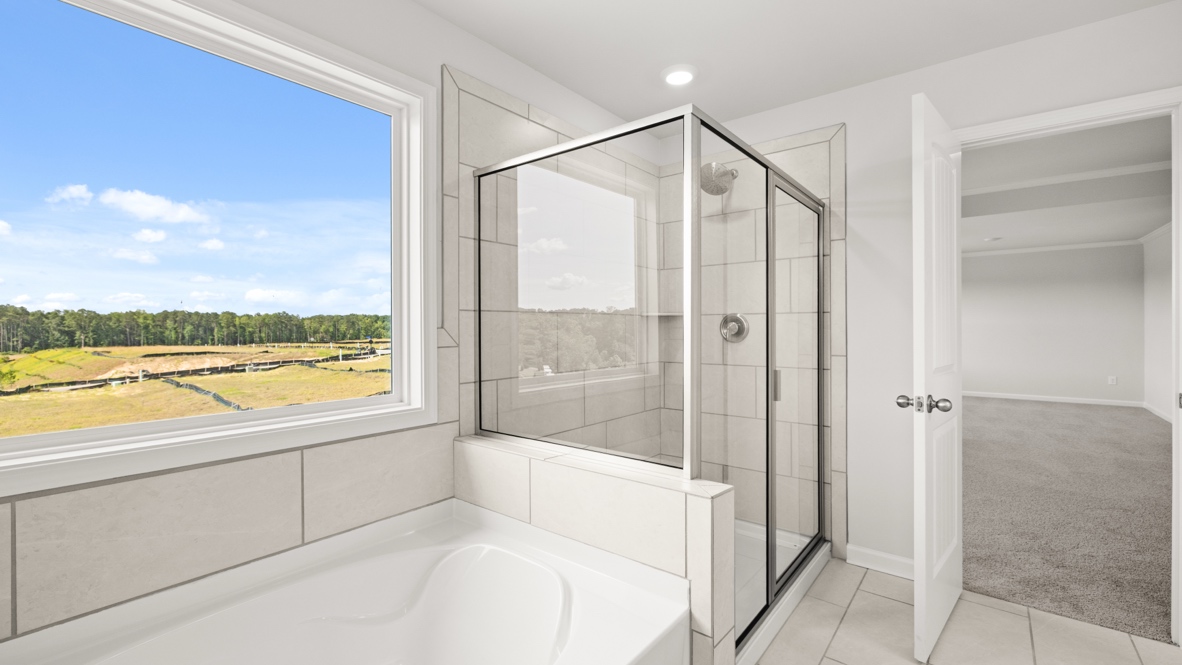 Interior primary bathroom with bath tub and shower
