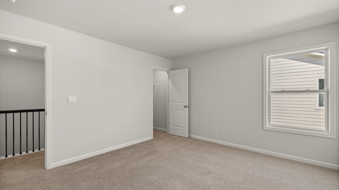 Interior upstairs loft area with large window and open to staircase