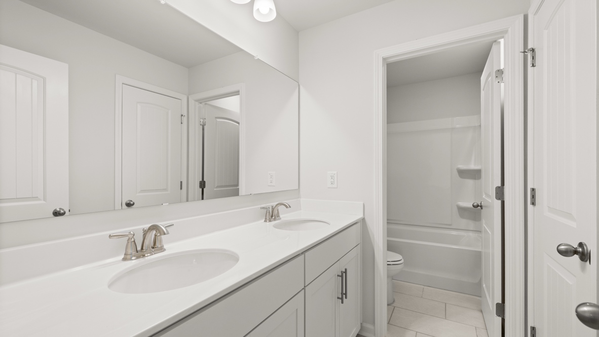 Interior bathroom with double sink and full-sized shower