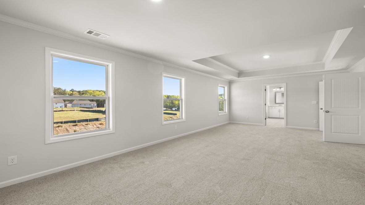 Interior primary bedroom with large windows
