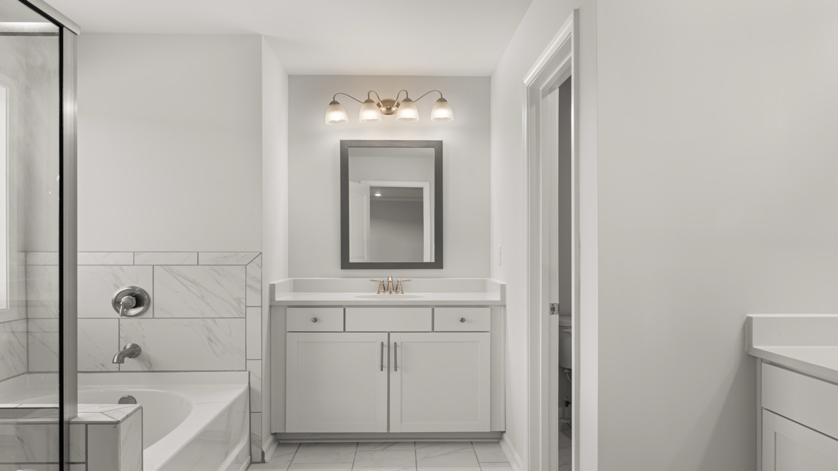 Interior primary bathroom with bath tub and shower