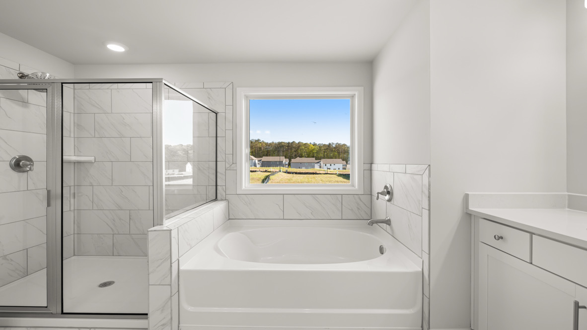 Interior primary bathroom with shower and bath tub