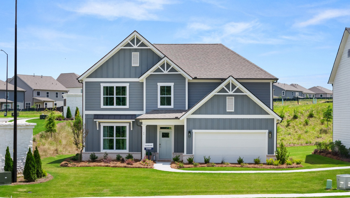 Two-story exterior home image with blue siding, white trim, and two-car garage.