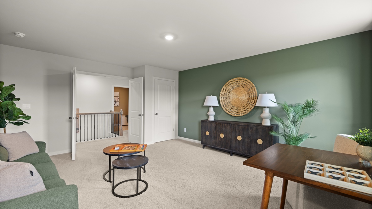 Loft  area with olive green walls, two windows and a couch