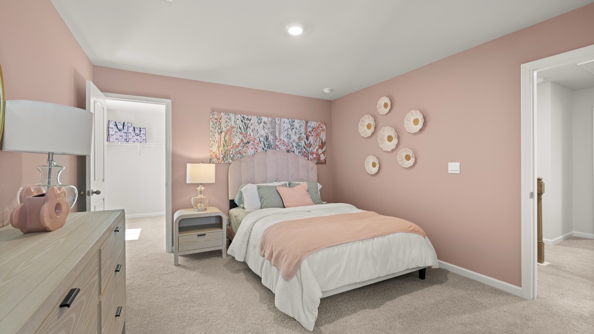 bedroom with pink walls, a bed and a white dresser