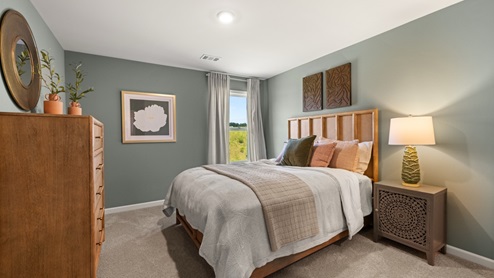 Bedroom wth green walls, carpeted floors, and a window.