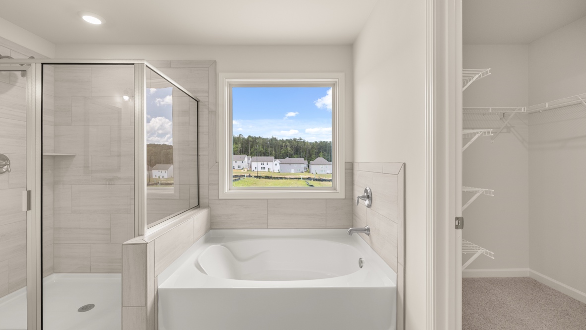 Interior primary bathroom with shower and bath tub