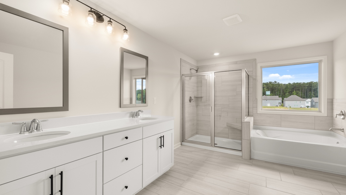 Interior primary bathroom with double sink, shower and bath tub