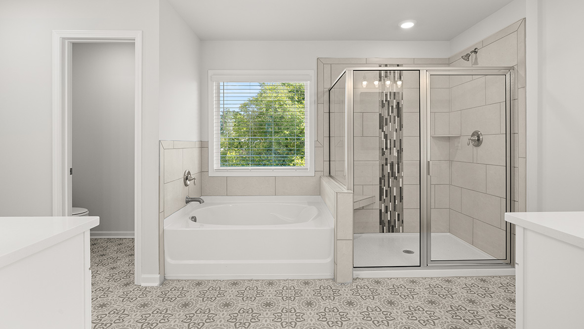 Interior primary bathroom with bath tub and shower