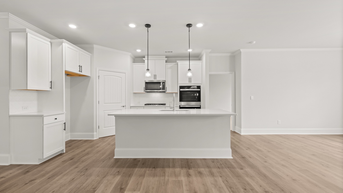 Interior kitchen with center island and white cabinets