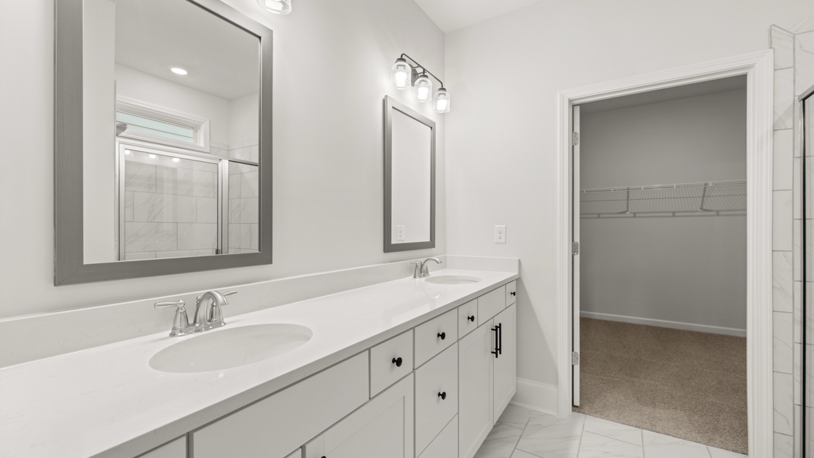 Interior primary bathroom with walk-in closet and double sink