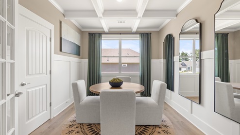 formal dining room with a round table and 4 grey chairs surrounding