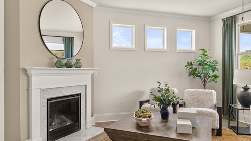 cozy living room with a grey sofa, two accent chairs and green curtains