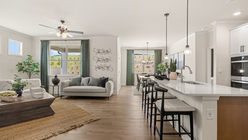 cozy living room with a grey sofa, two accent chairs and green curtains