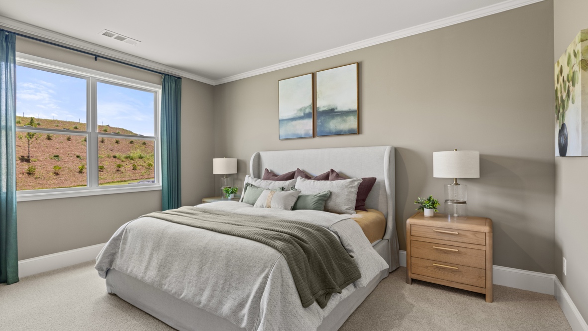 bedroom with a grey bed, brown dresser and a large window with teal curtains