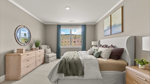 bedroom with a grey bed, brown dresser and a large window with teal curtains