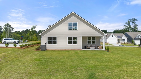 rear exterior of home featuring a spacious backyard