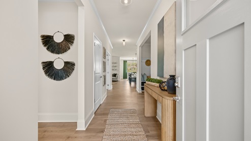 Front entry hallway of the home featuring brown flooring and white walls