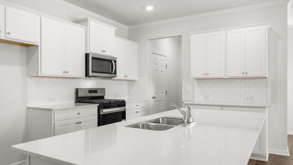 Interior kitchen with center island and white cabinets