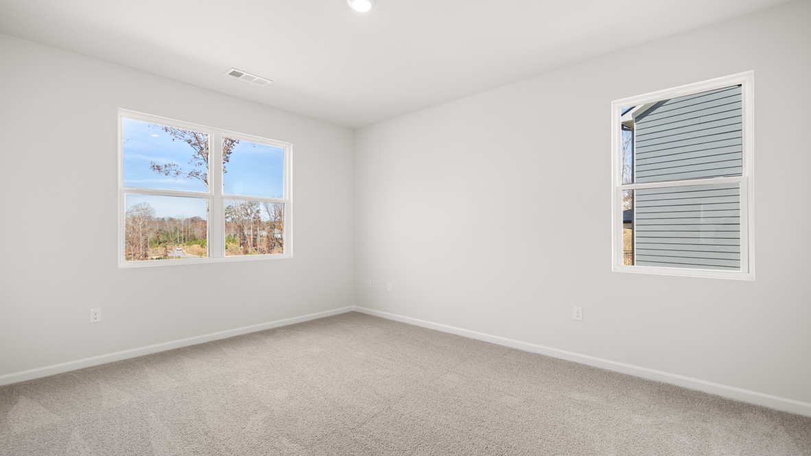 Interior primary bedroom with large windows