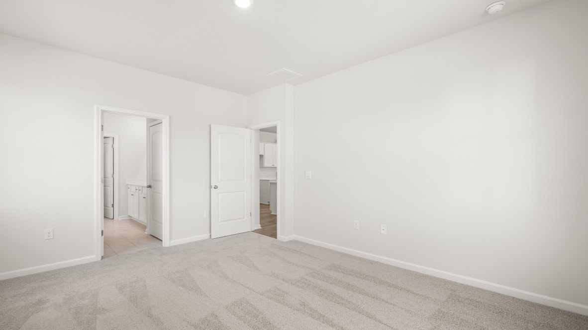 Interior primary bedroom with large windows