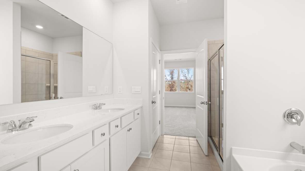 Interior primary bathroom with double sink and bath tub