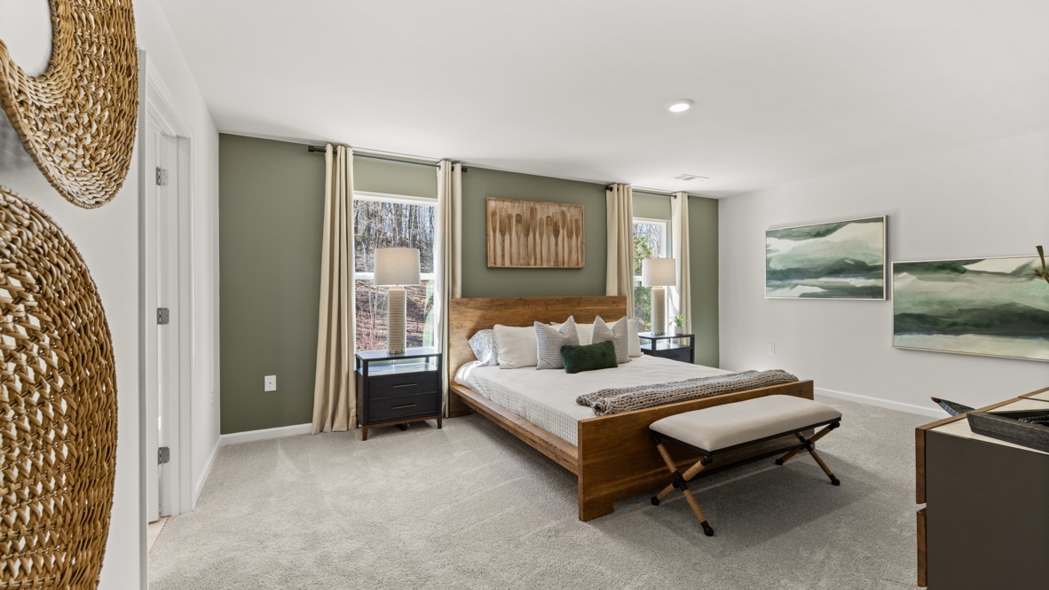 Interior primary bedroom with windows and accent wall