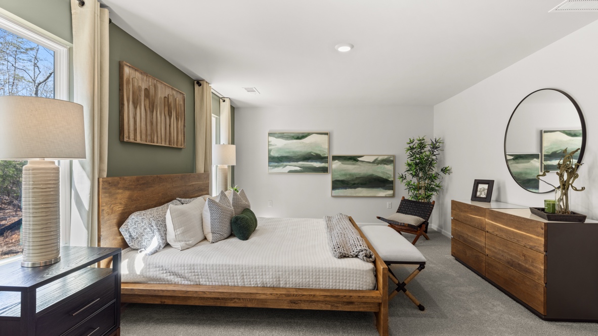 Interior primary bedroom with windows and accent wall