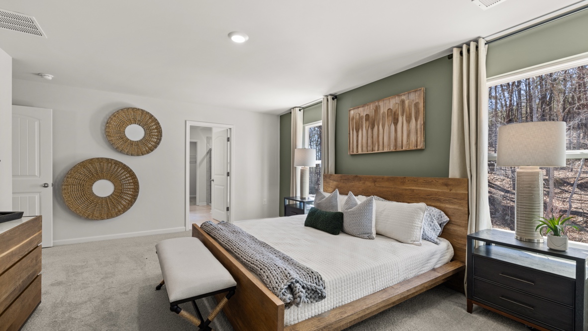 Interior primary bedroom with windows and accent wall