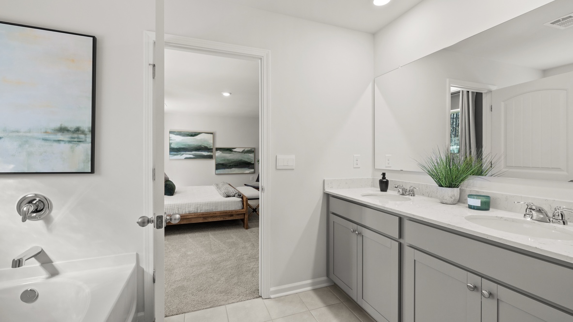 Interior primary bathroom with double sink and walk-in closet