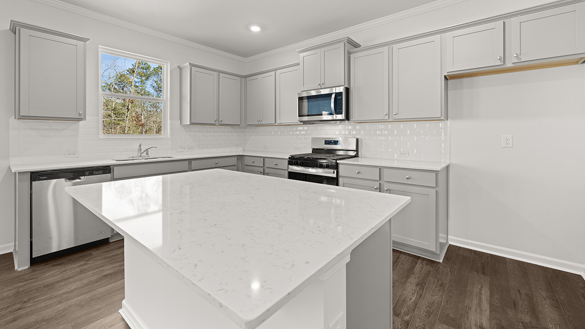 kitchen with light grey cabinetry, large island and stainless steel appliances
