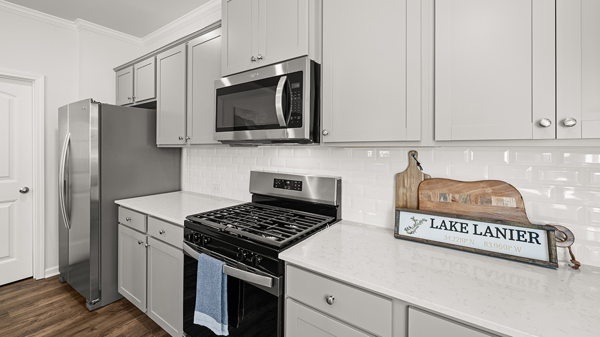Interior kitchen open to living area with windows