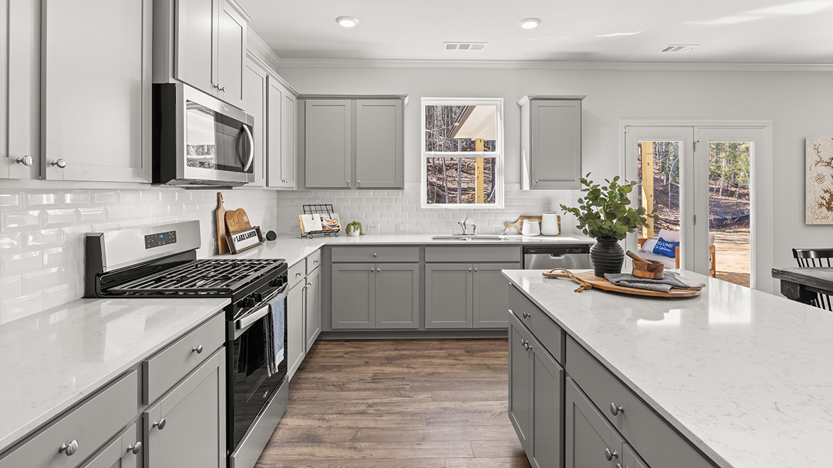 Interior kitchen open to living area with windows