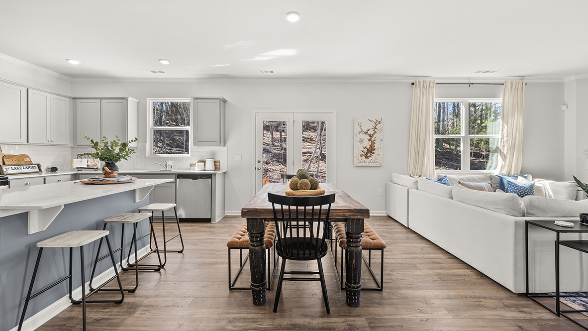 Interior kitchen open to living area with windows