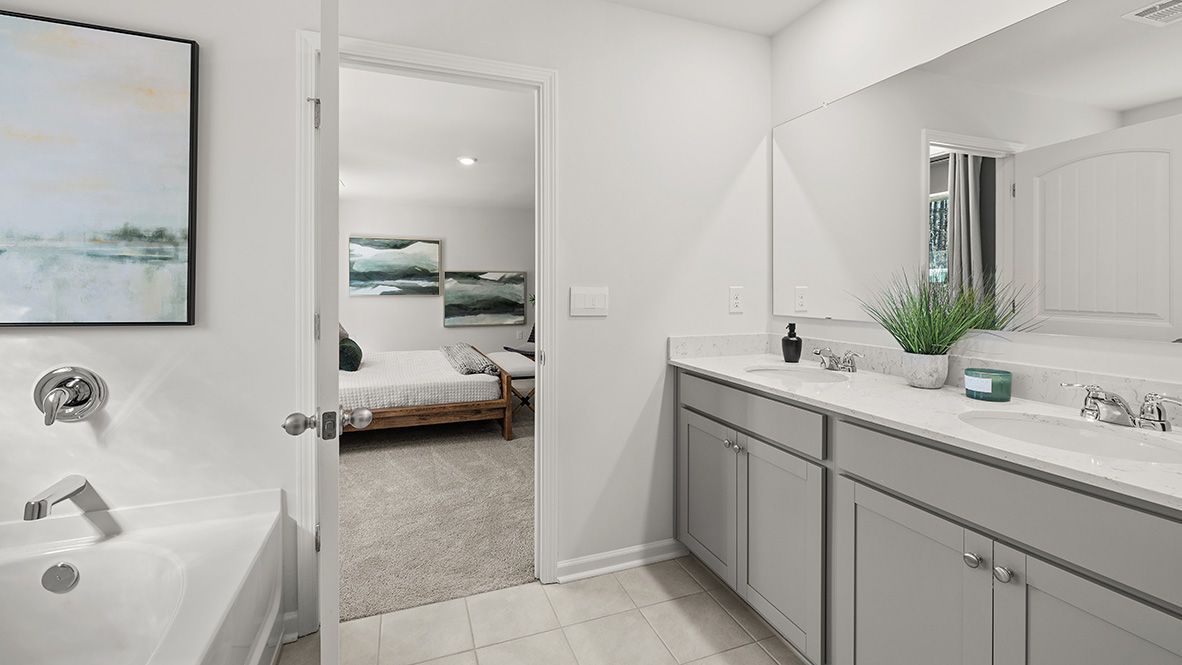 Interior primary bathroom with double sink, shower and walk in closet