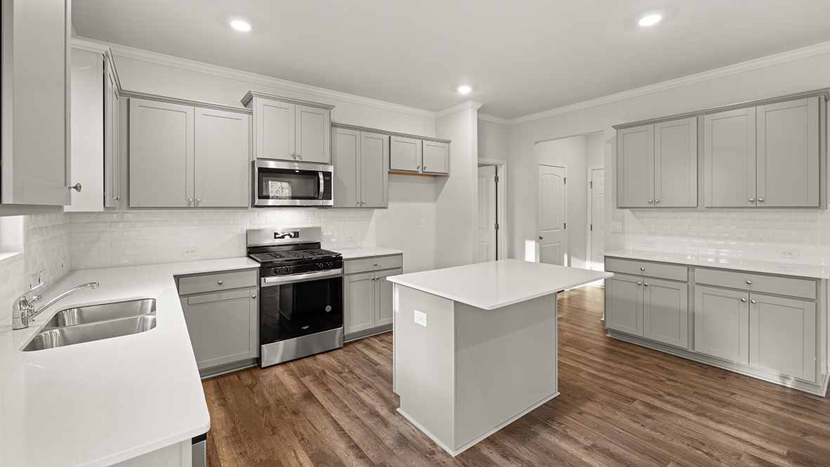 kitchen with light grey cabinetry, large island and stainless steel appliances