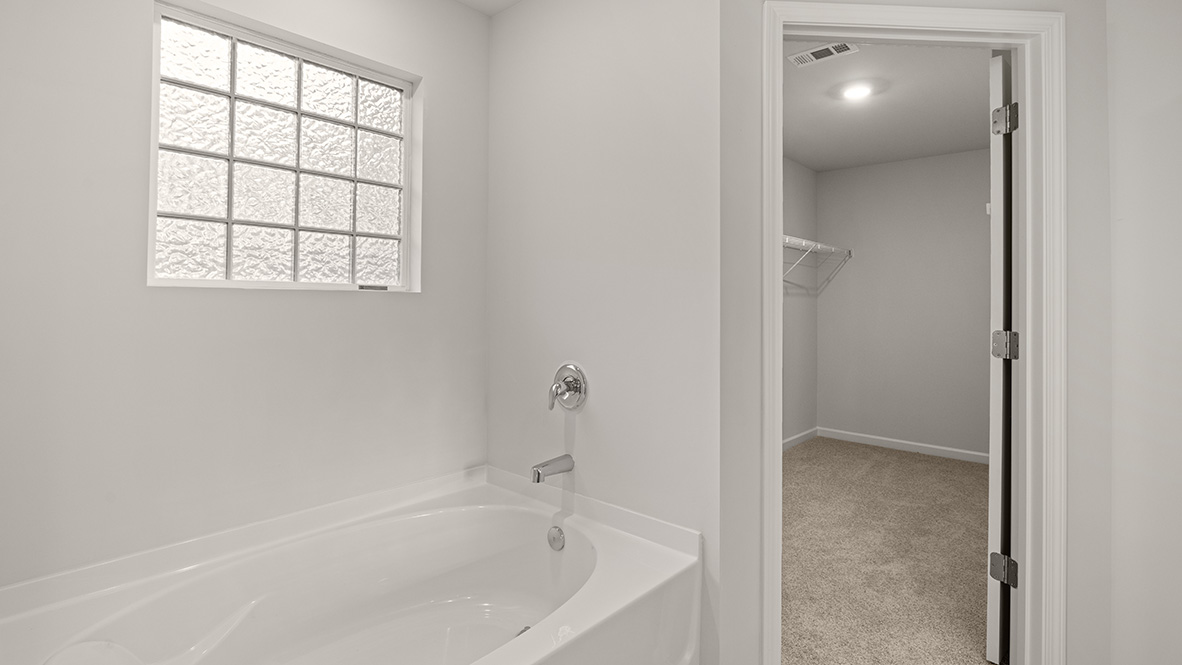 bathroom with dual vanity sinks, and a walk in shower