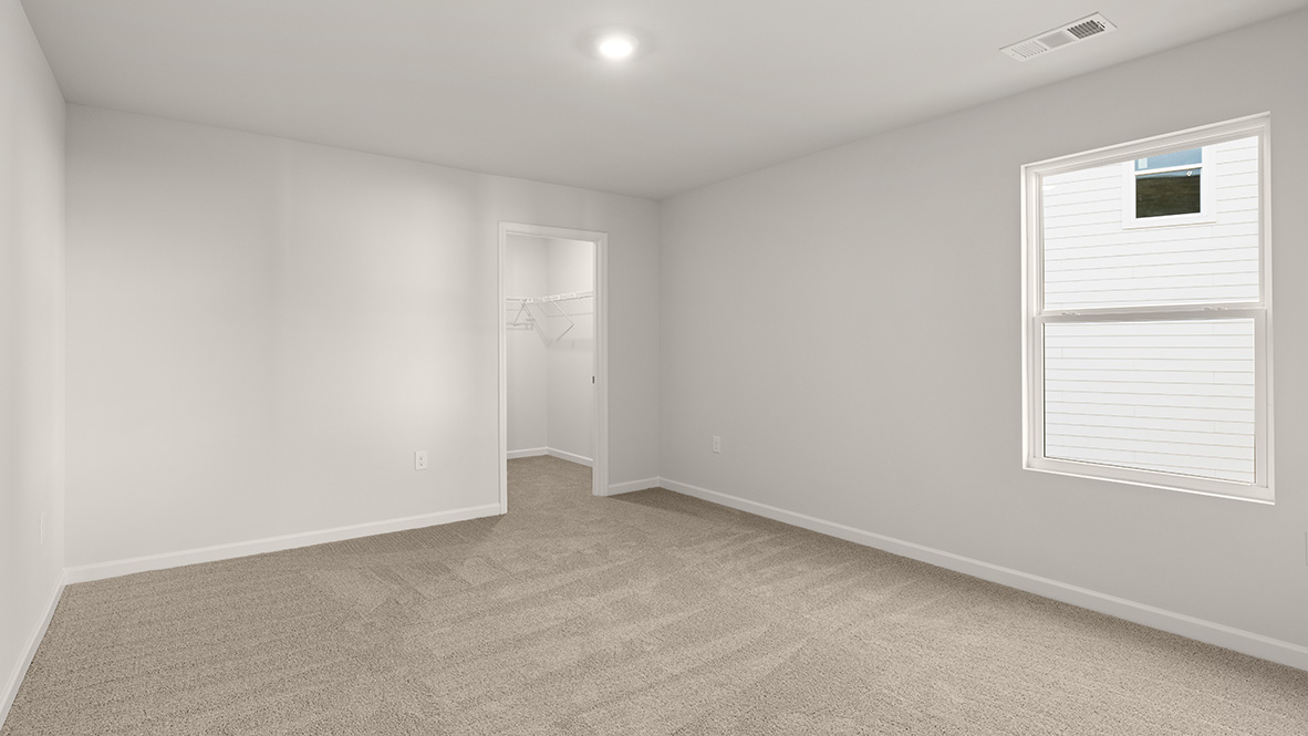 bedroom with beige carpet, white walls and a window