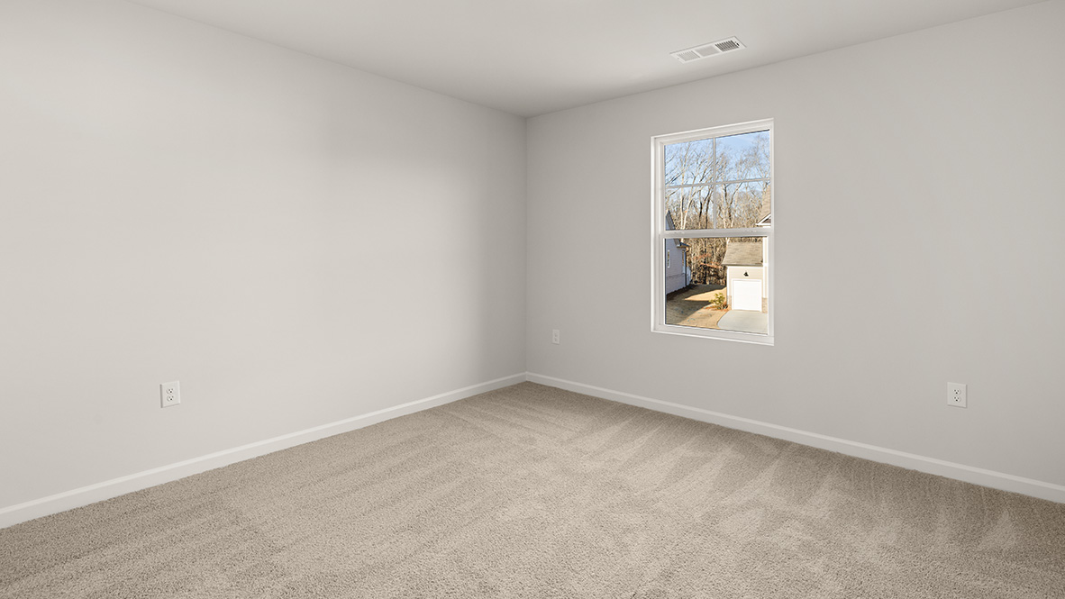 bedroom with beige carpet, white walls and a window