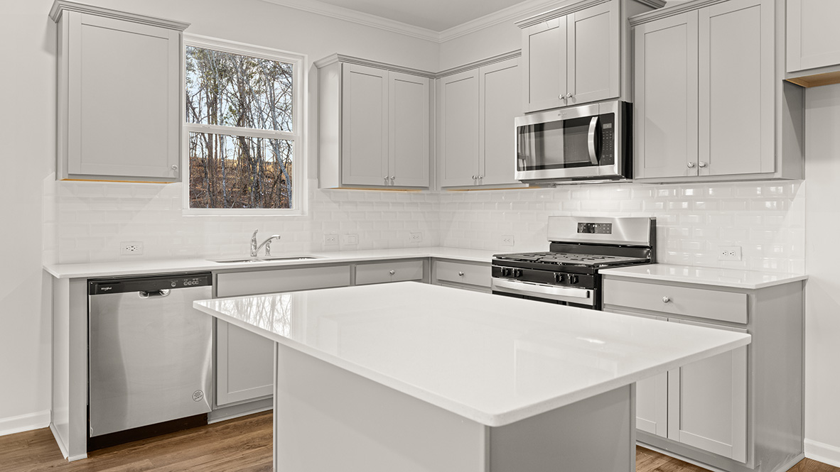 Kitchen with gray cabinets, a window, and stainless steel appliances