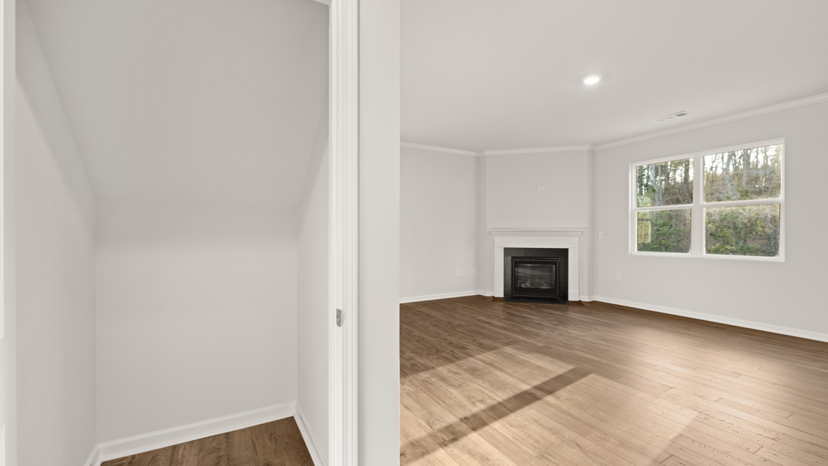 Interior hallway with hall closet leading to living area