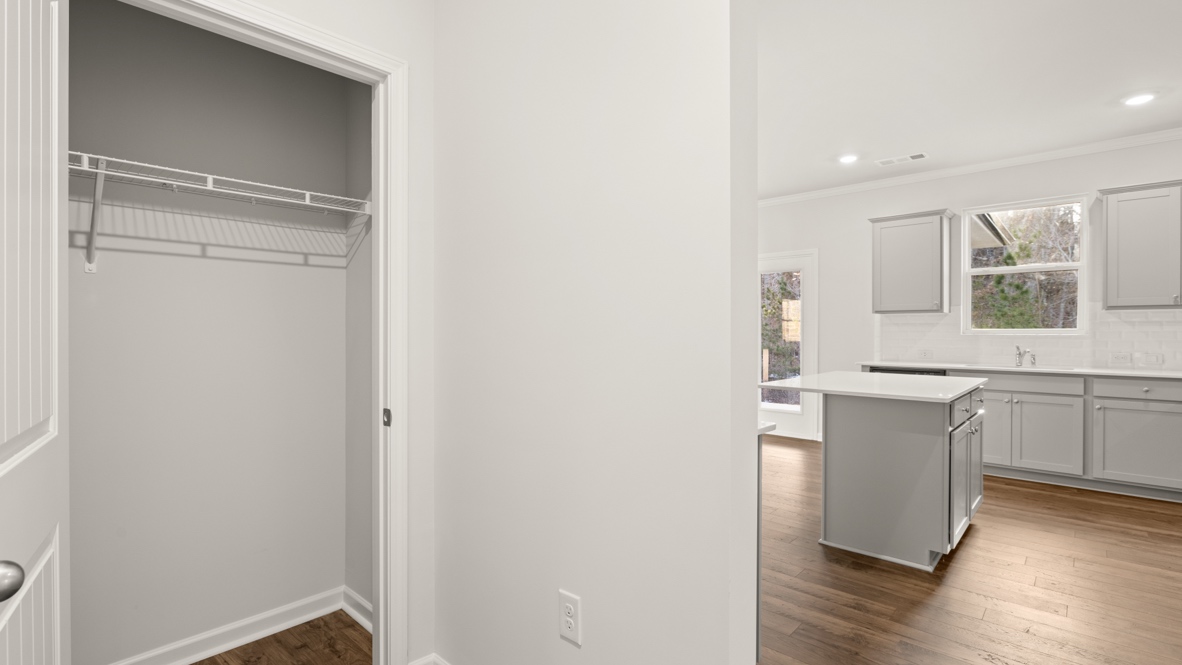 Interior hallway with hall closet leading to kitchen