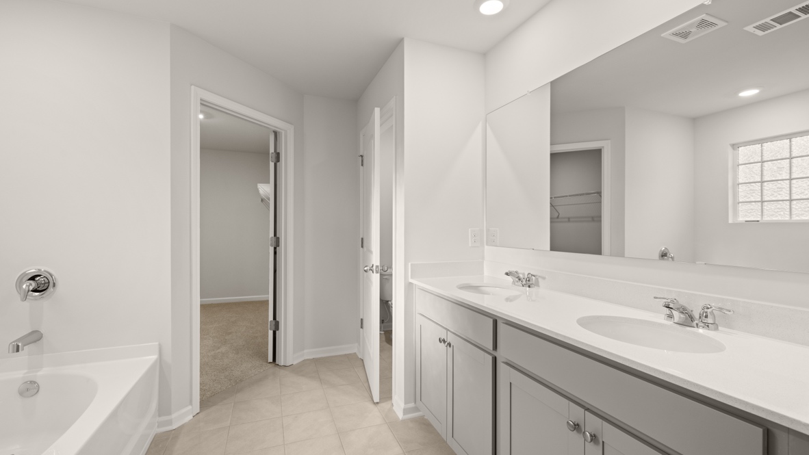 Interior primary bathroom with double sink and bath tub