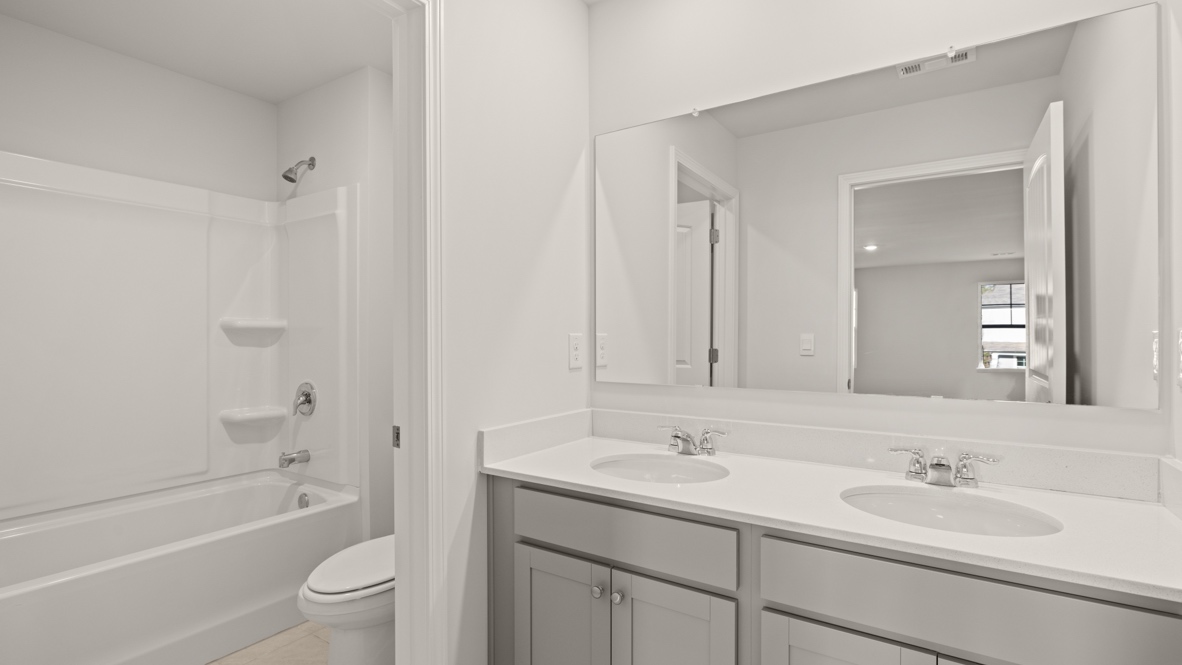 Interior bathroom with double sink and full-sized shower