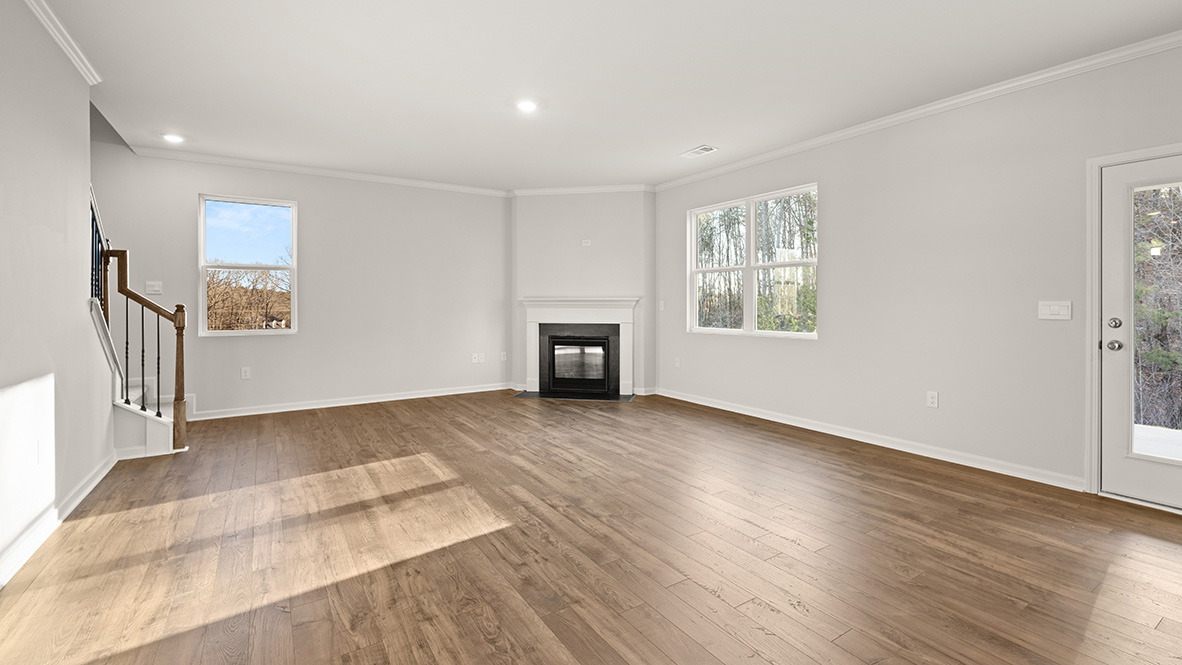 Interior living area with windows and fire place next to staircase