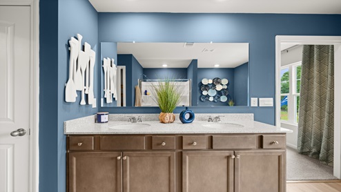 Ensuite double vanity sinks with granite counter tops, and natural wood beveled flat panel cabinets.