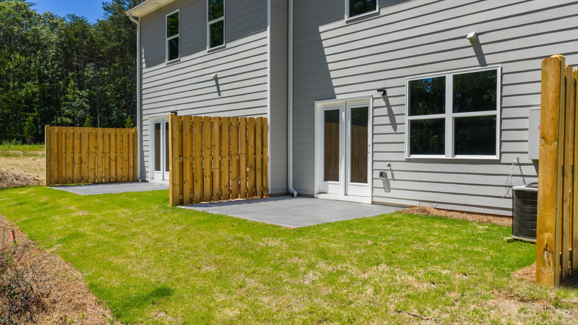 Rear exterior of home with concrete slab.